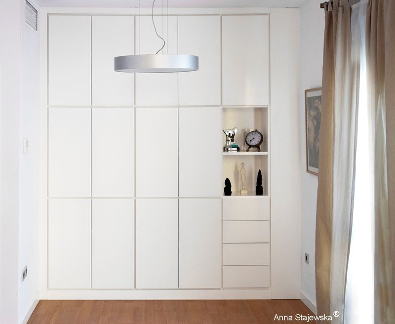 Armario lacado blanco integrado discretamente en el salón para resolver el problema de falta de espacio en los armarios de la casa