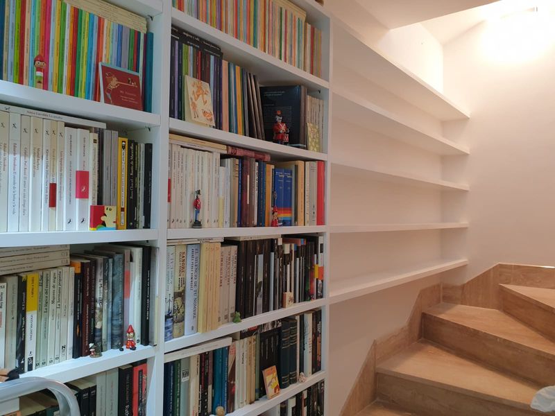 Libreria ajustada a la pared de la escalera